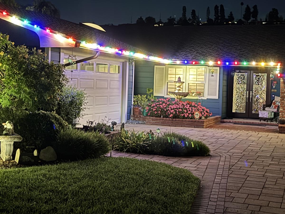 Camarillo home with multicolor roofline lights above a brick walkway