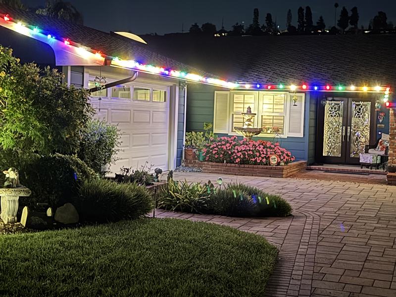Camarillo home with multicolor roofline lights above a brick walkway
