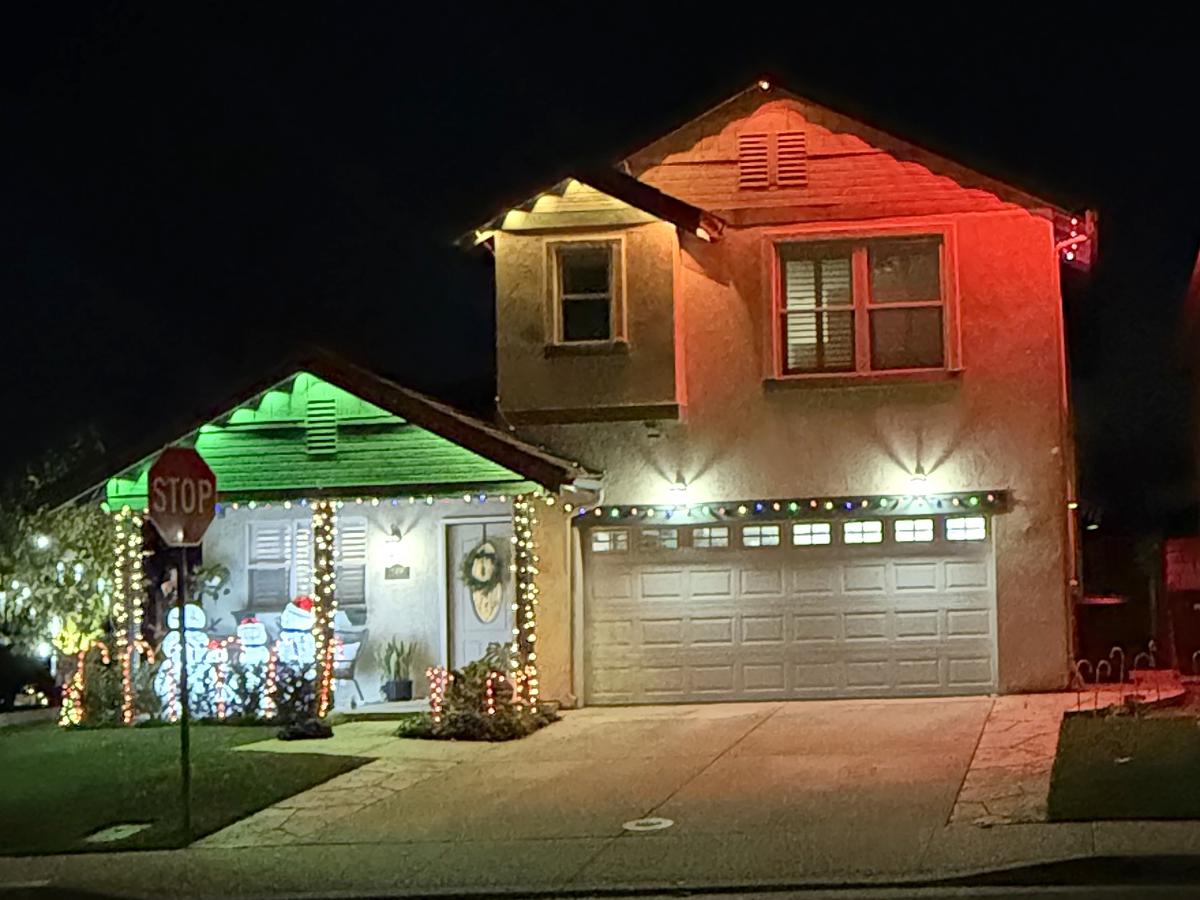 Moorpark home with red and green color wash lights and wrapped porch posts