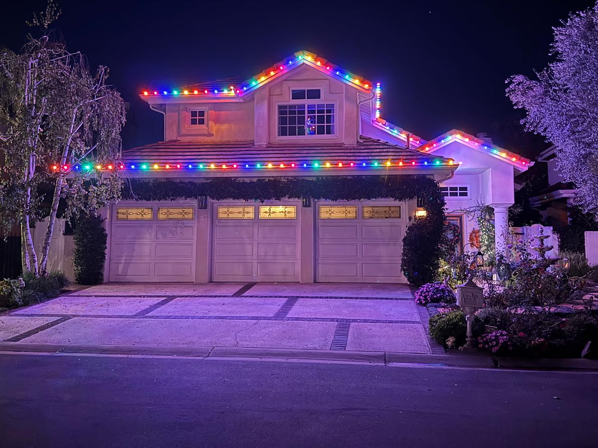 Two-story home with multicolor lights along every roofline