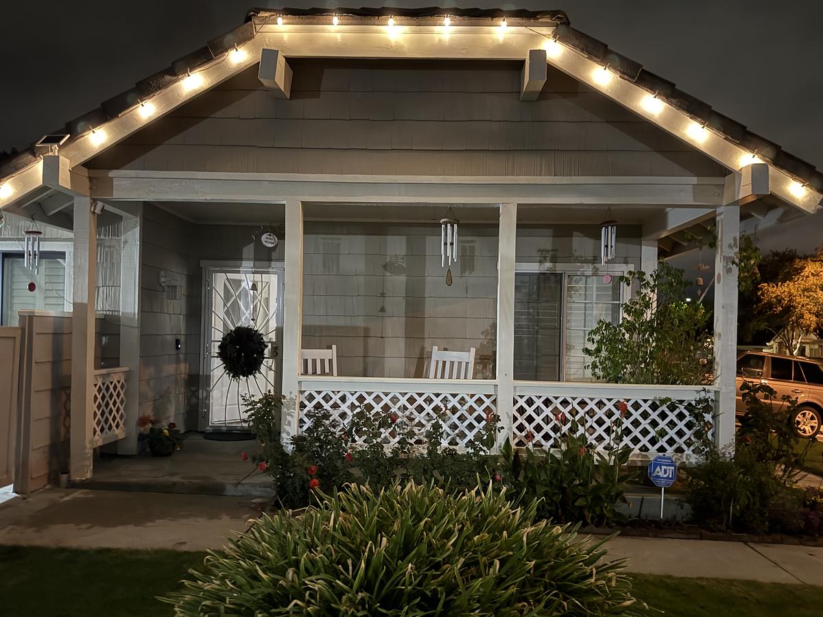 Craftsman porch in Santa Clarita with warm white lights on the gable and a wreath on the door