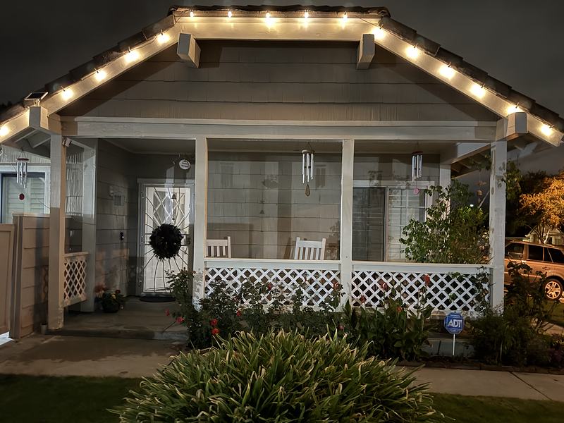 Craftsman porch in Santa Clarita with warm white lights on the gable and a wreath on the door